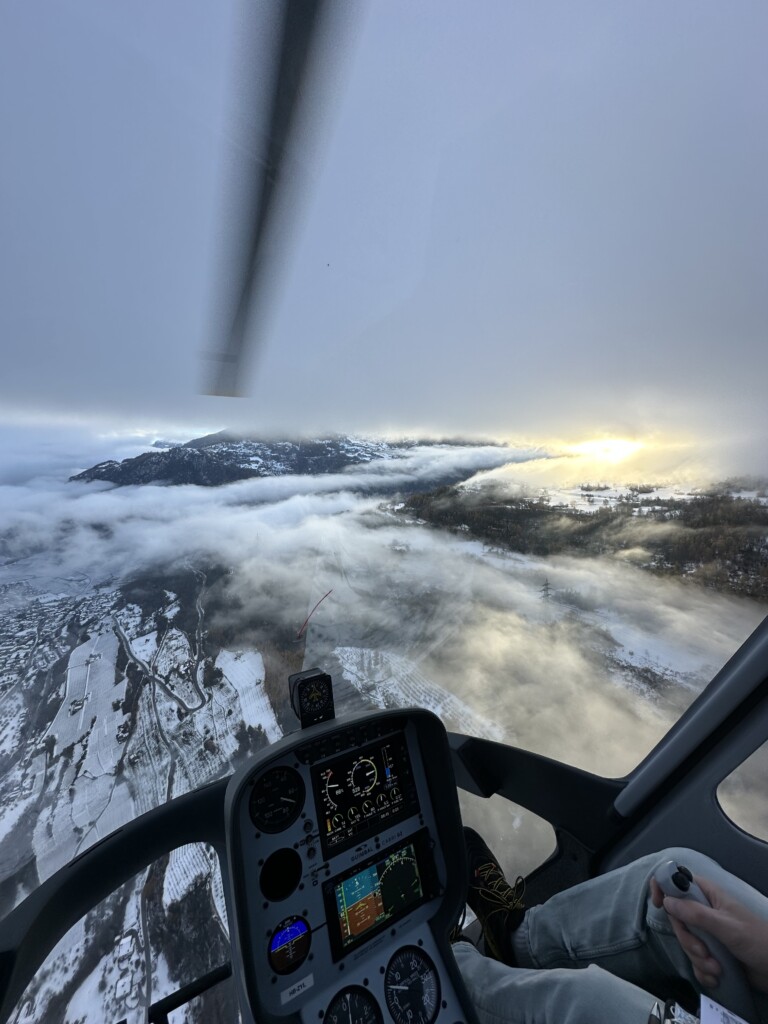 Vue immersive depuis le cockpit vitré de l'hélicoptère Bell 505, offrant une perspective privilégiée sur le paysage alpin suisse et illustrant l’expérience unique proposée par le Chablais Heli Club
