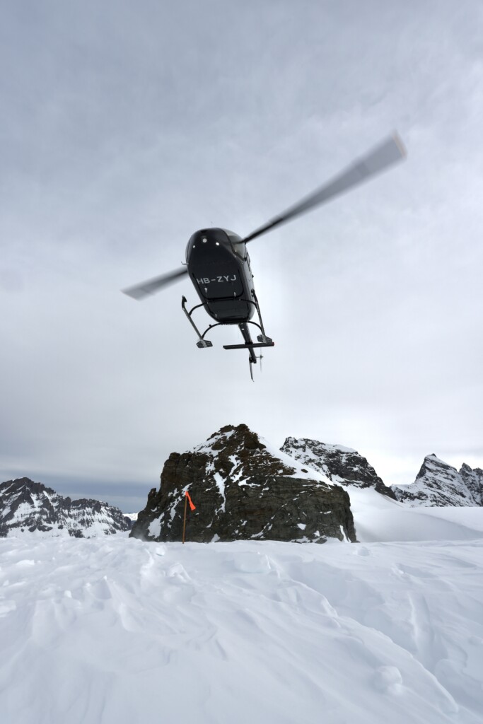 Photographie d’un hélicoptère atterrissant en montagne dans les Alpes suisses, illustrant la maîtrise technique des pilotes et l’accès privilégié aux reliefs alpins avec le Chablais Heli Club