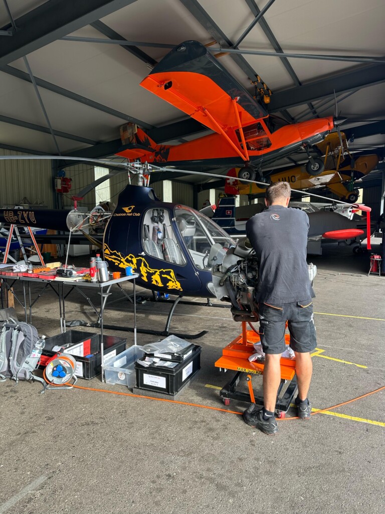 Image montrant un technicien/mécanicien réalisant la maintenance d’un hélicoptère dans le hangar du Chablais Heli Club à Bex. Cette photo illustre les standards élevés de sécurité et de fiabilité appliqués à chaque appareil