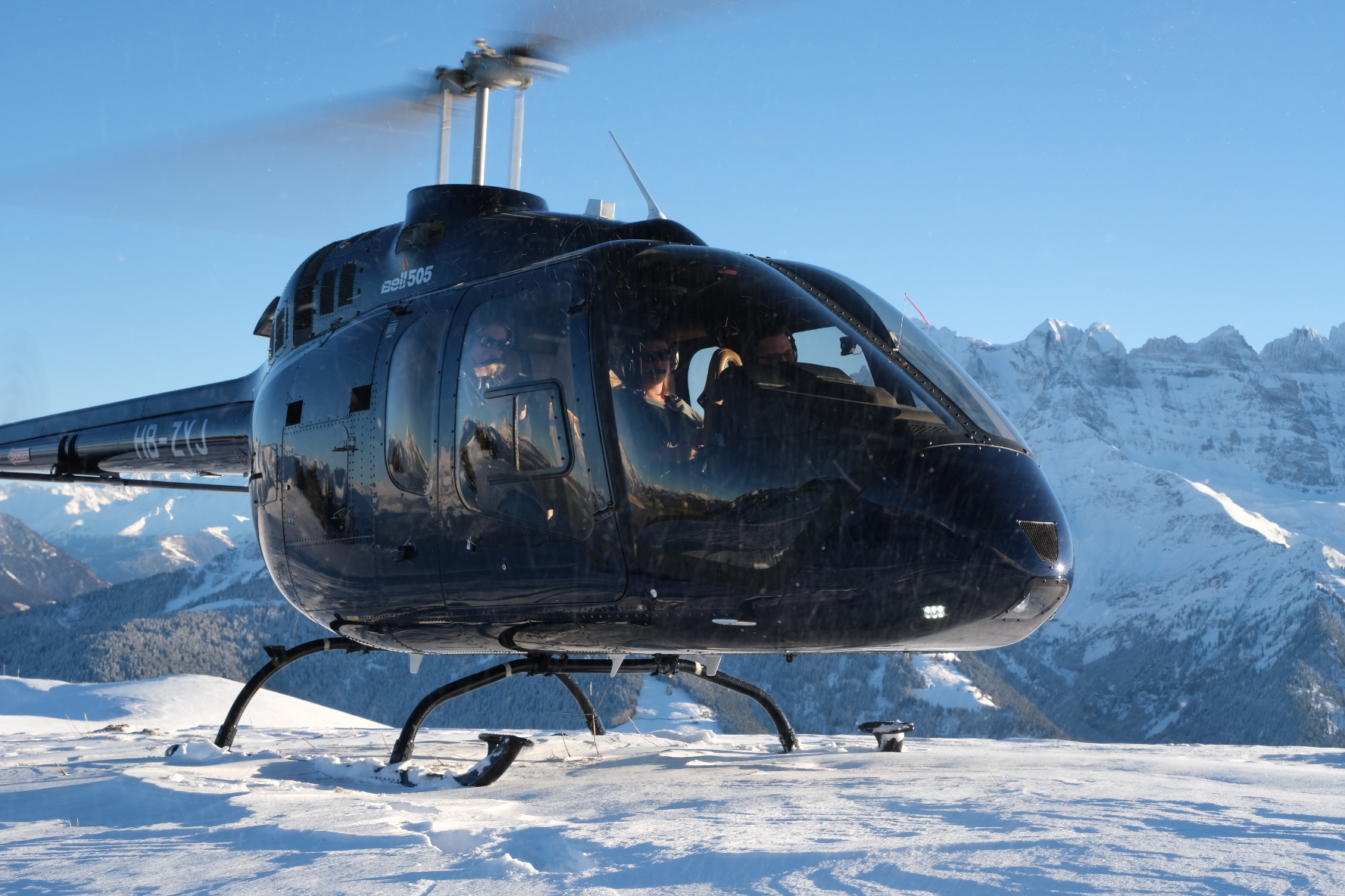 Hélicoptère évoluant près des crêtes pour illustrer la formation TR (Turbine) Description : Image d’un hélicoptère en vol près des reliefs alpins, illustrant la formation de type rating (TR) proposée par le Chablais Heli Club pour piloter des hélicoptères à turbine
